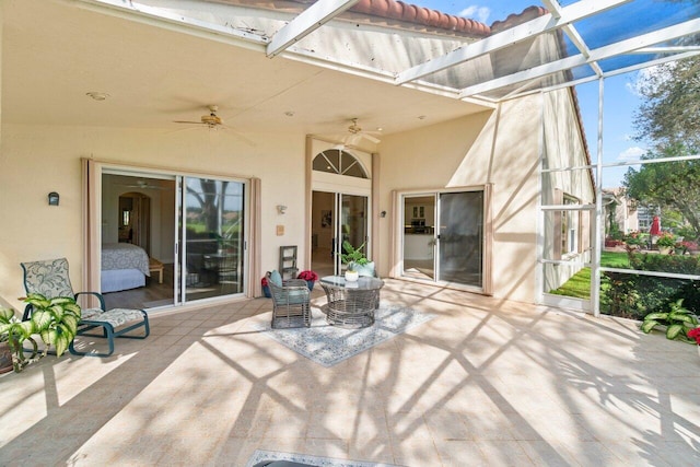 view of patio / terrace featuring glass enclosure and a ceiling fan