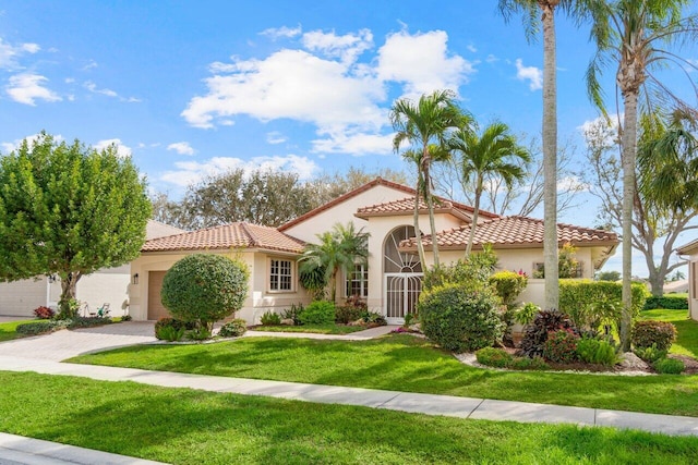 mediterranean / spanish house with stucco siding, a tile roof, an attached garage, decorative driveway, and a front yard