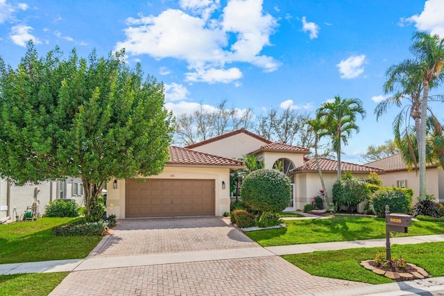 mediterranean / spanish-style home featuring a front lawn, decorative driveway, an attached garage, and stucco siding