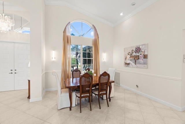 dining area with light tile patterned floors, baseboards, ornamental molding, a high ceiling, and a notable chandelier