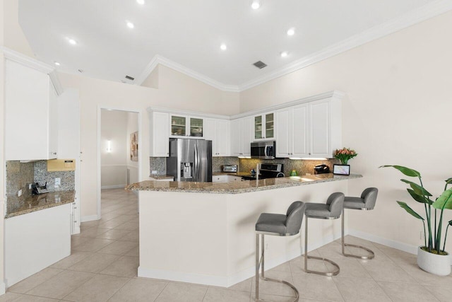 kitchen featuring stainless steel appliances, a peninsula, glass insert cabinets, and white cabinets