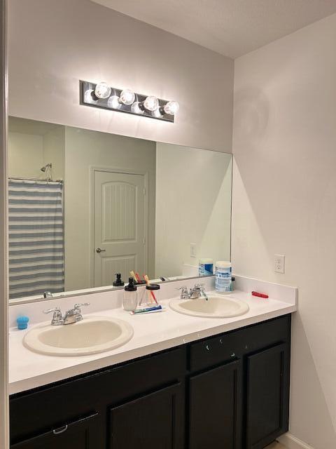 full bathroom with double vanity and a sink