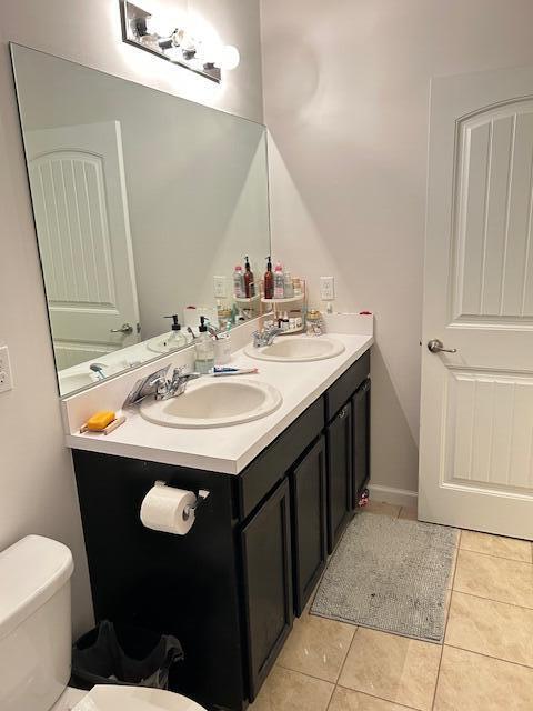 bathroom featuring tile patterned flooring, a sink, and toilet