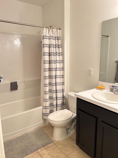 bathroom featuring shower / tub combo, vanity, toilet, and tile patterned floors