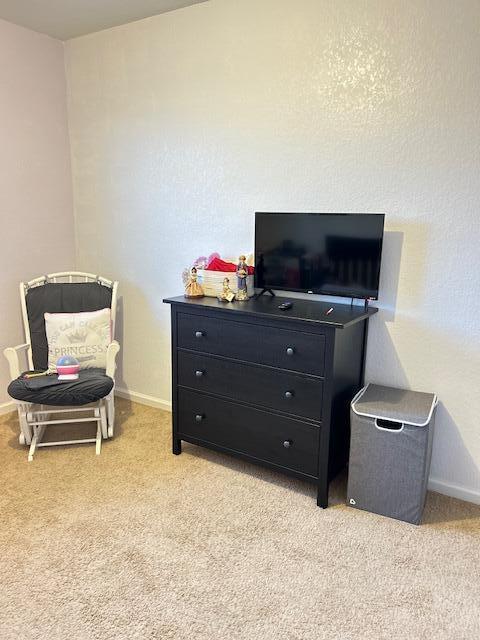 bedroom with light carpet and baseboards