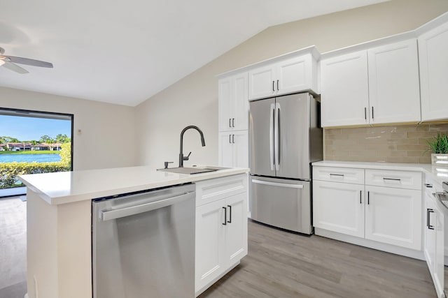 kitchen with appliances with stainless steel finishes, light countertops, white cabinets, and a sink