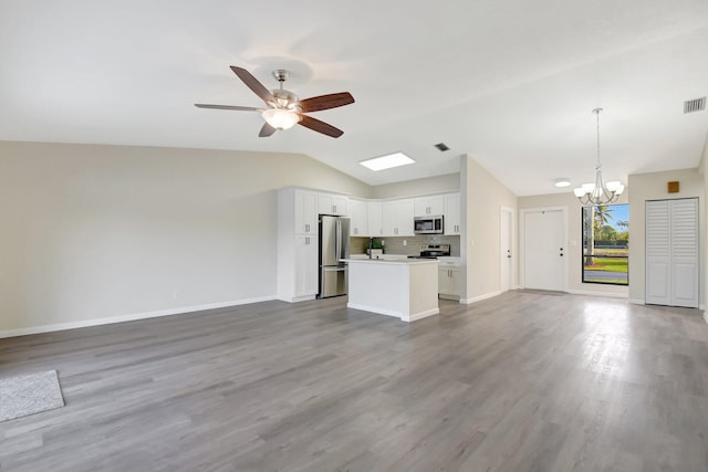 kitchen with white cabinets, open floor plan, light countertops, appliances with stainless steel finishes, and pendant lighting