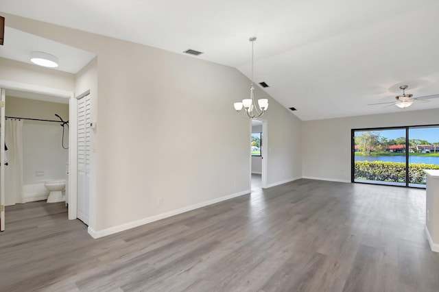 empty room featuring a healthy amount of sunlight, baseboards, visible vents, and wood finished floors