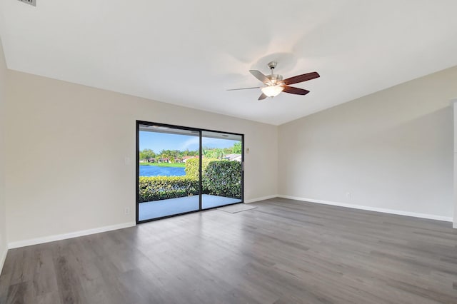 unfurnished room featuring dark wood finished floors, baseboards, and ceiling fan