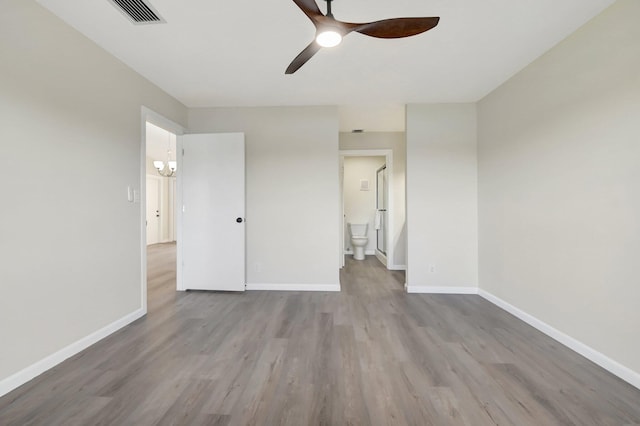 unfurnished bedroom featuring light wood finished floors, visible vents, a ceiling fan, ensuite bath, and baseboards