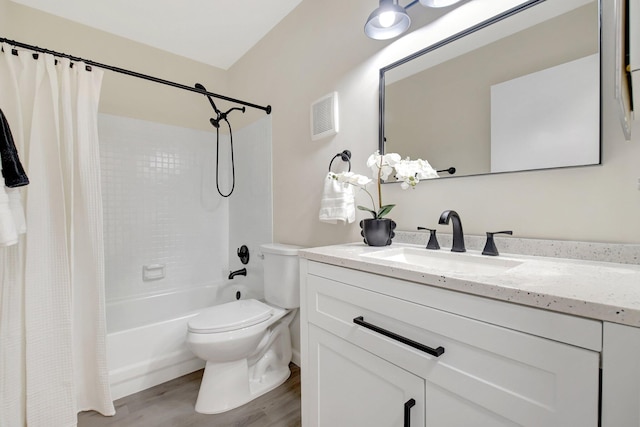 bathroom featuring toilet, wood finished floors, vanity, visible vents, and shower / bath combo with shower curtain