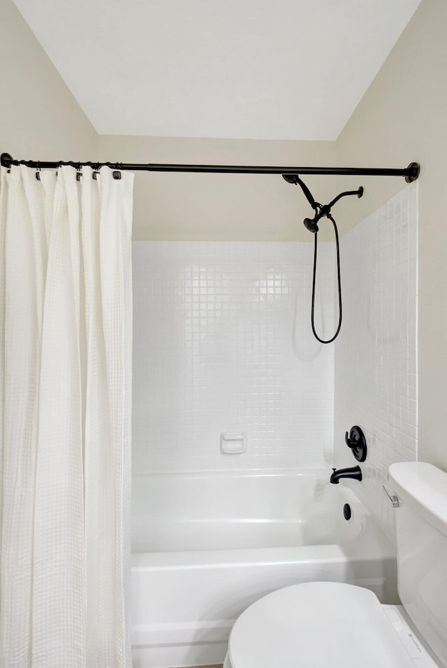 bathroom with shower / bath combination with curtain and toilet