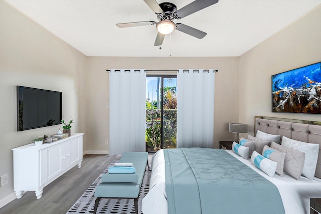 bedroom with wood finished floors, a ceiling fan, and baseboards