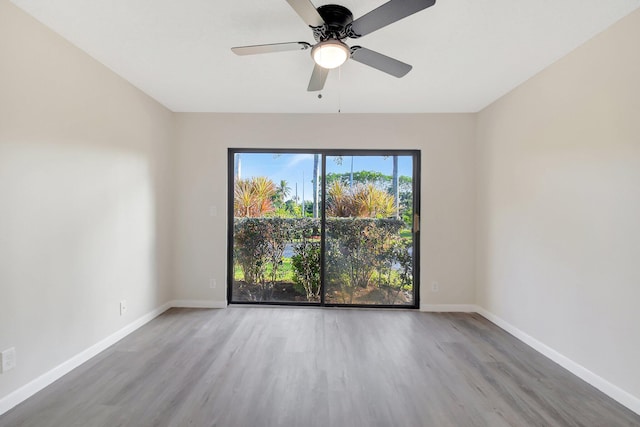 unfurnished room with a ceiling fan, baseboards, and wood finished floors