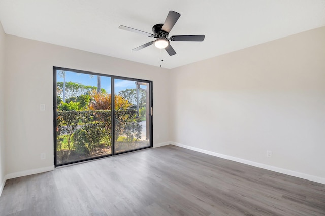 empty room with a ceiling fan, baseboards, and wood finished floors