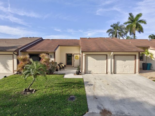 view of front of home with a garage, driveway, roof with shingles, stucco siding, and a front lawn