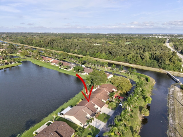 birds eye view of property featuring a water view and a wooded view