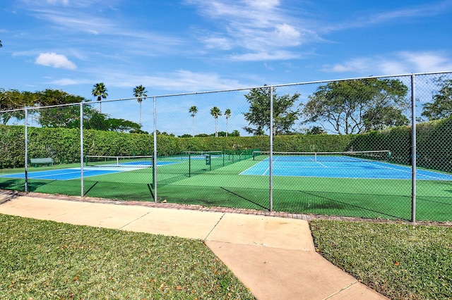 view of sport court featuring a yard and fence