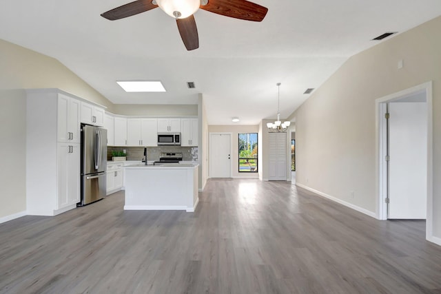 kitchen featuring open floor plan, light countertops, appliances with stainless steel finishes, and white cabinets