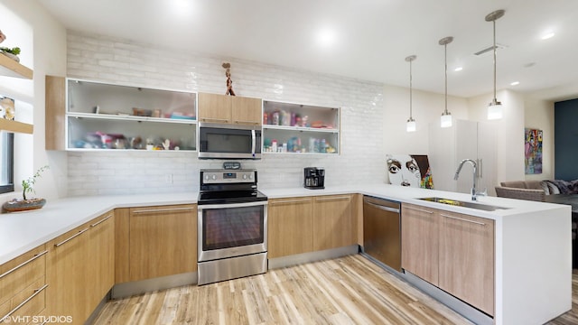 kitchen with tasteful backsplash, a peninsula, stainless steel appliances, open shelves, and a sink