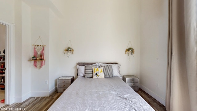 bedroom with baseboards and wood finished floors