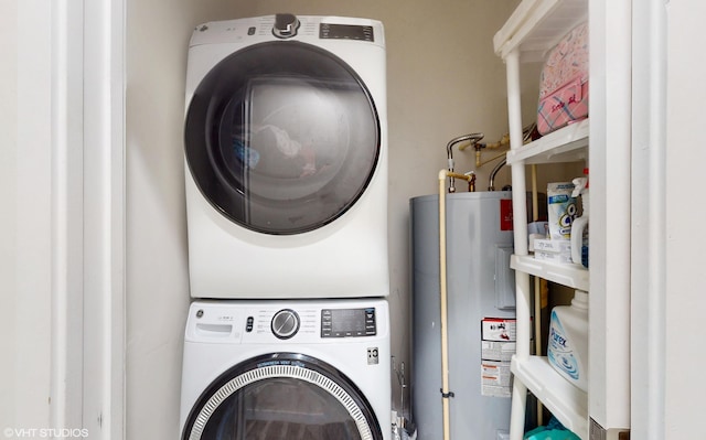 laundry room featuring water heater, stacked washer and dryer, and laundry area