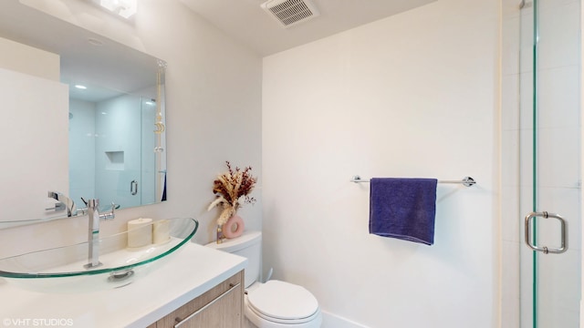 bathroom featuring visible vents, vanity, a shower stall, and toilet