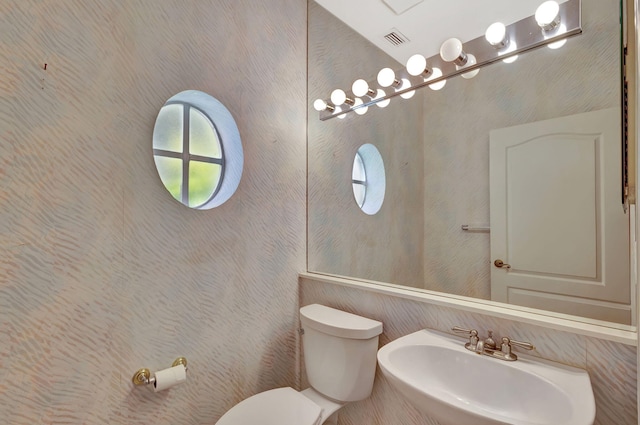 bathroom featuring toilet, visible vents, and a sink