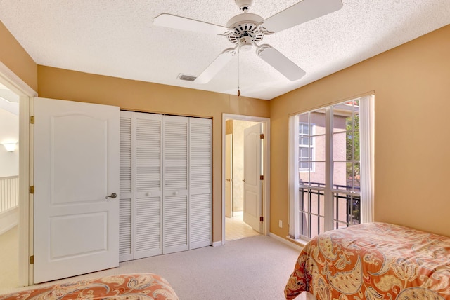 bedroom featuring access to outside, visible vents, a textured ceiling, and light colored carpet