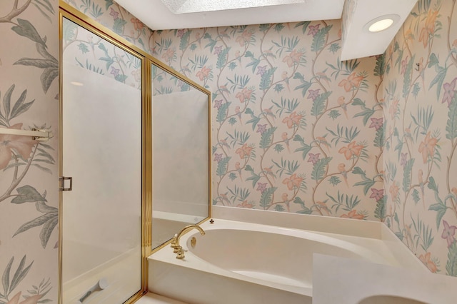 bathroom with wallpapered walls, a shower stall, a skylight, and a bath