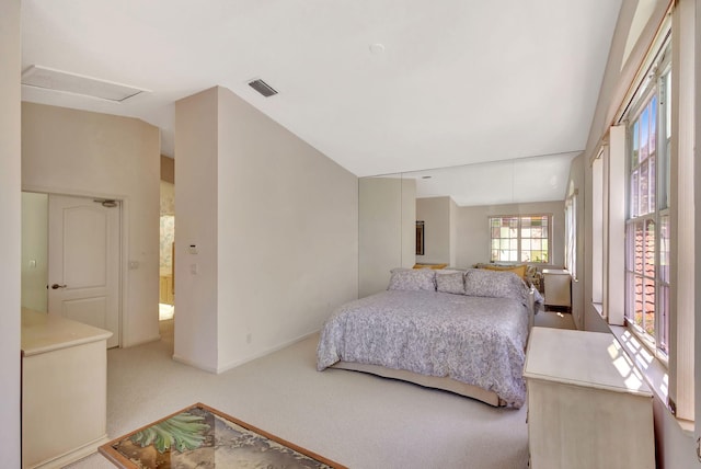 carpeted bedroom with lofted ceiling, baseboards, and visible vents