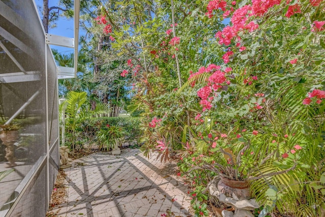 view of patio featuring glass enclosure