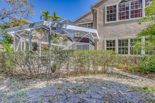 exterior space with a lanai and stucco siding