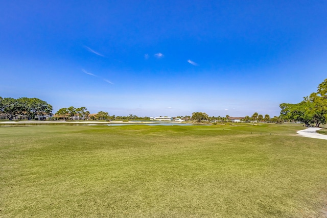 view of community with view of golf course and a lawn