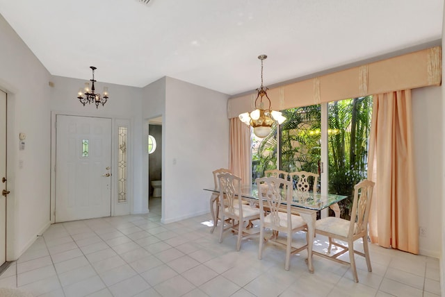 dining area with light tile patterned flooring, baseboards, and an inviting chandelier