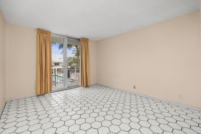 empty room featuring baseboards and tile patterned floors