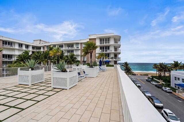 view of patio / terrace featuring a water view and a beach view