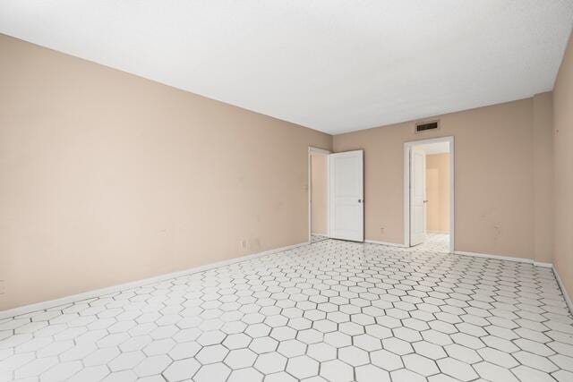 empty room with visible vents and baseboards