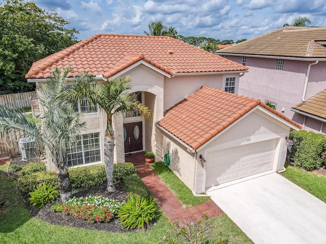 mediterranean / spanish-style home with driveway, a tile roof, an attached garage, and stucco siding