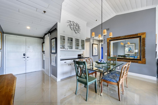 dining room featuring lofted ceiling, a barn door, light tile patterned flooring, visible vents, and baseboards