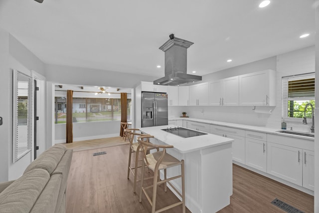 806 S 12th St, Fort Pierce, FL 34950 - kitchen with stainless steel fridge, white cabinetry, and light countertops