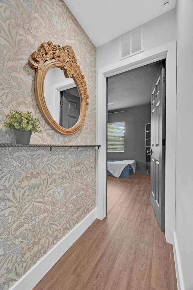 806 S 12th St, Fort Pierce, FL 34950 - hall featuring wallpapered walls, baseboards, visible vents, and wood finished floors
