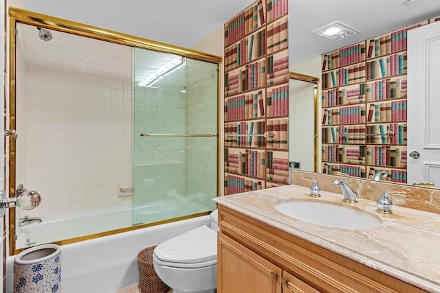 full bath featuring vanity, toilet, and bath / shower combo with glass door