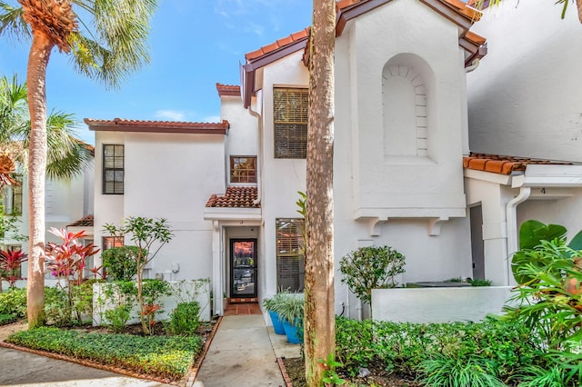 exterior space featuring a tile roof and stucco siding