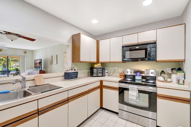 kitchen featuring white cabinetry, black microwave, light countertops, and electric stove