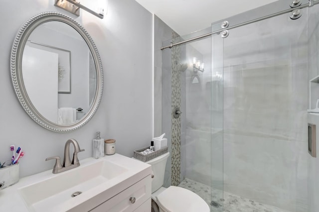 full bathroom featuring vanity, a shower stall, and toilet