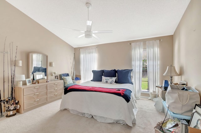 bedroom featuring lofted ceiling, light carpet, ceiling fan, and a textured ceiling