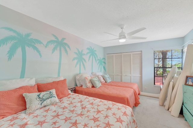 bedroom featuring a textured ceiling, a ceiling fan, a closet, and light colored carpet