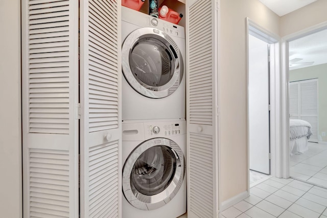 washroom with laundry area, stacked washer / dryer, and light tile patterned flooring