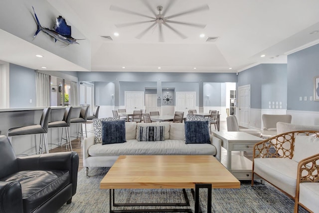 living room with a wainscoted wall, recessed lighting, and visible vents
